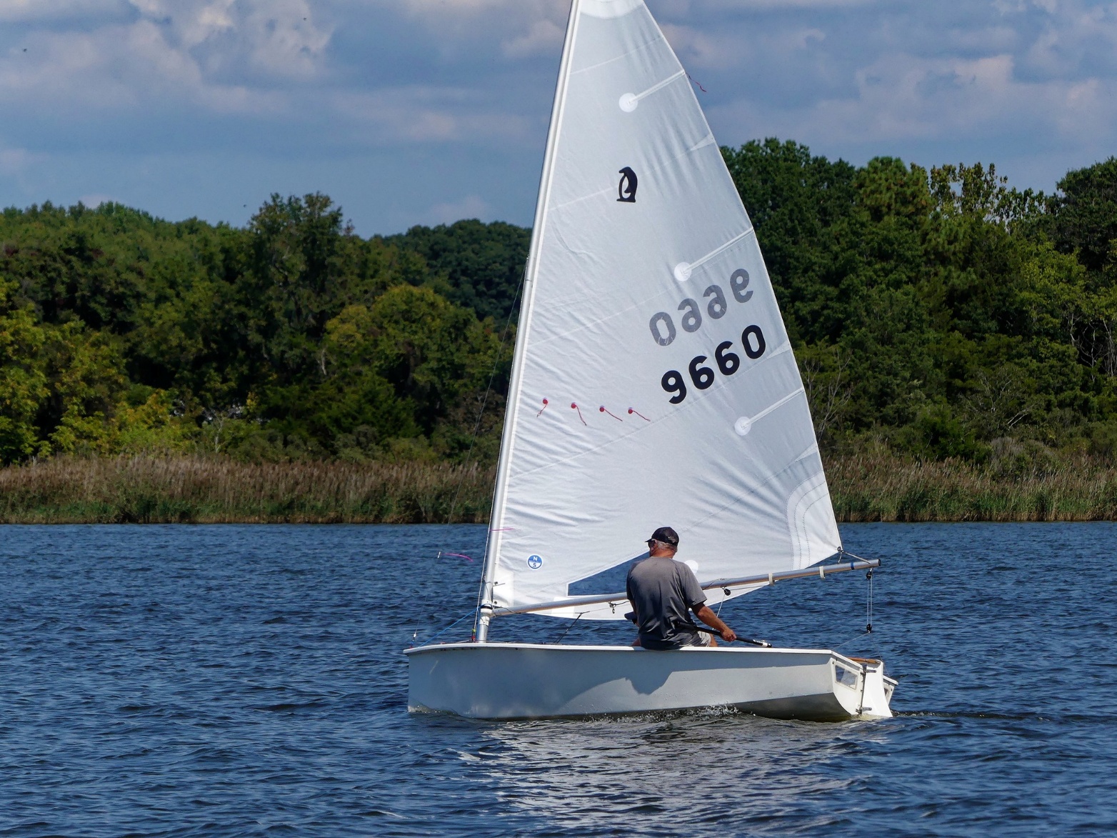 A person in a sailboat on a lake AI-generated content may be incorrect.